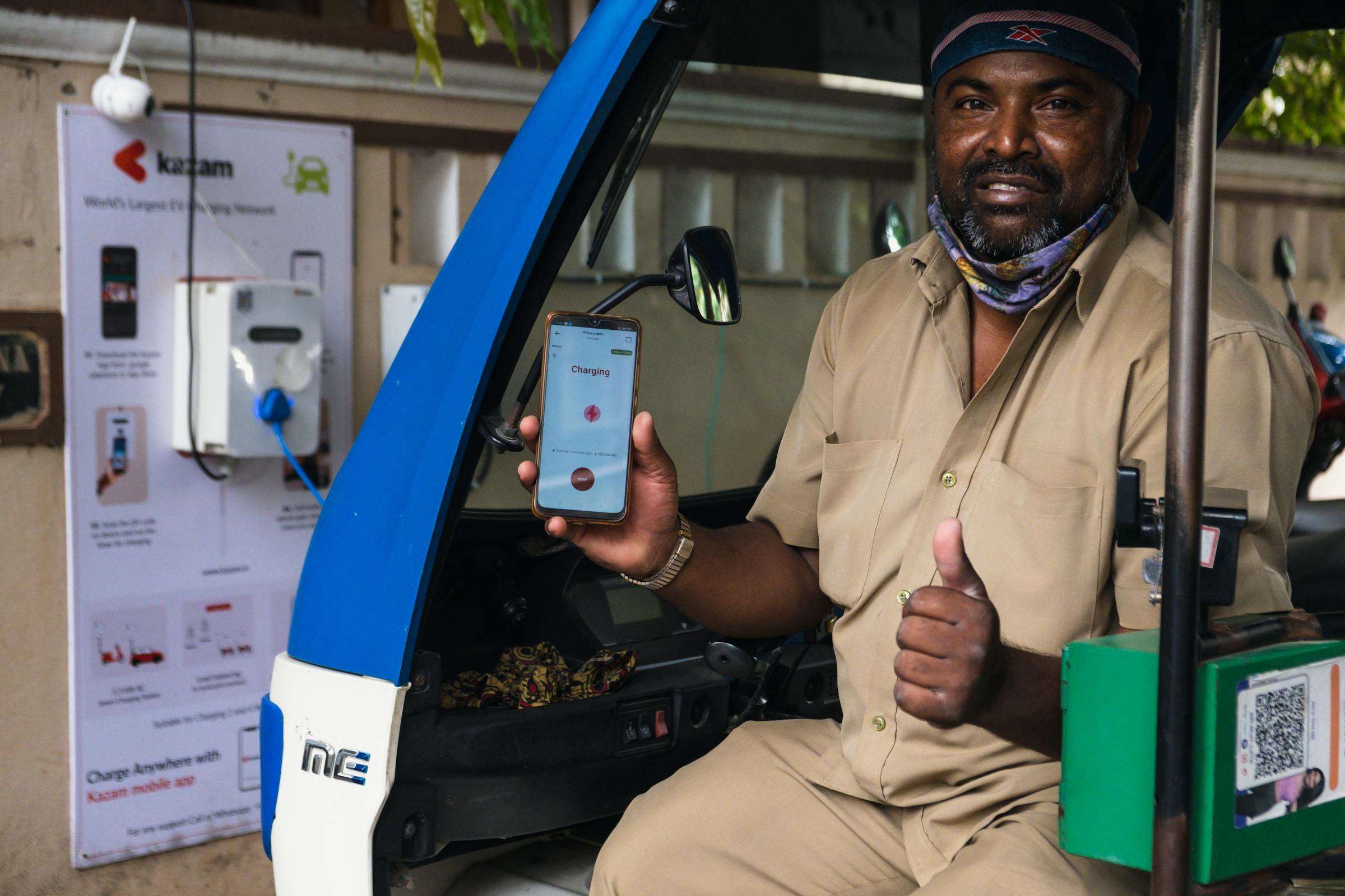 Conducente che usa il suo smartphone a un punto di ricarica